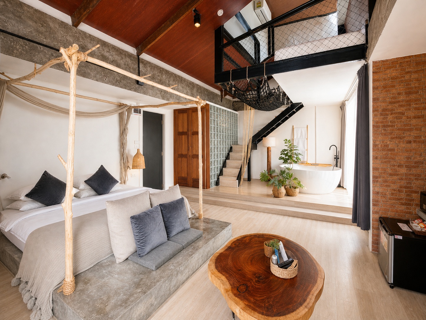 YOLO Aloft Suite with a timber canopy bed, sleeping mezzanine, rope hammock, staircase and freestanding bathtub