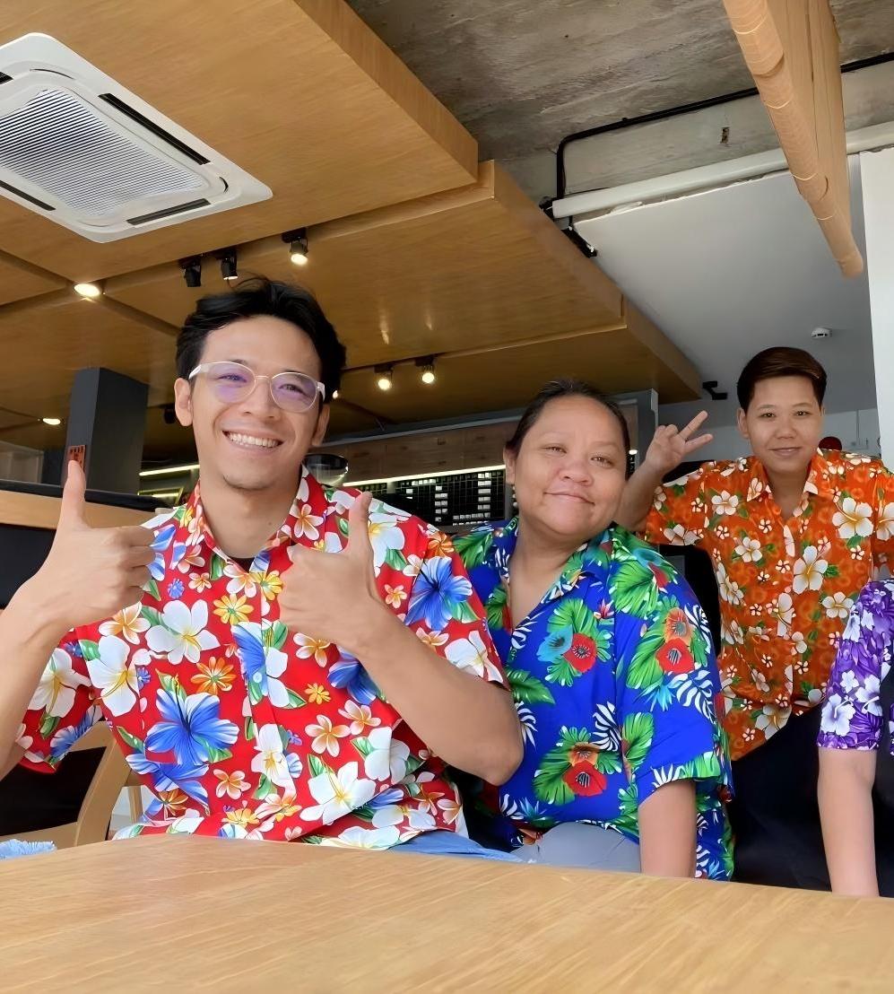The YOLO team together at the cafe, smiling in colourful floral shirts